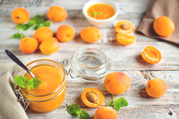 jar with homemade apricot jam on a light wooden background