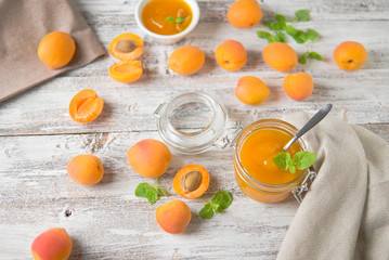 jar with homemade apricot jam on a light wooden background