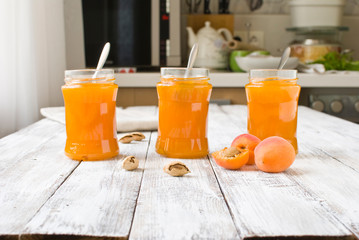 jar with homemade apricot jam on a light wooden background