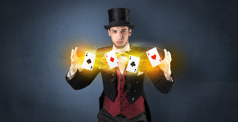 Illusionist in tails bandy play cards between his two hands