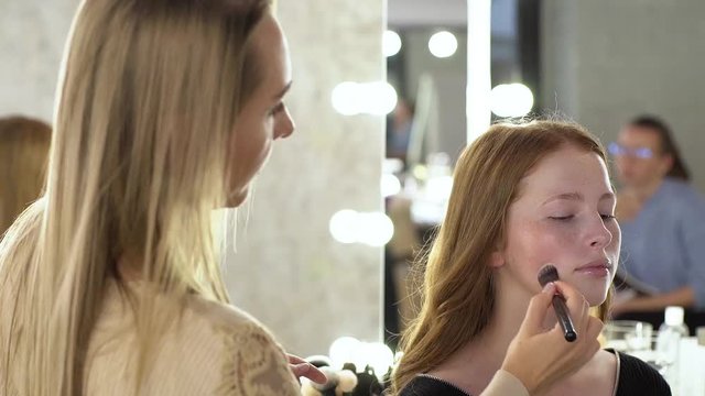 Makeup artist applying make-up on face of model
