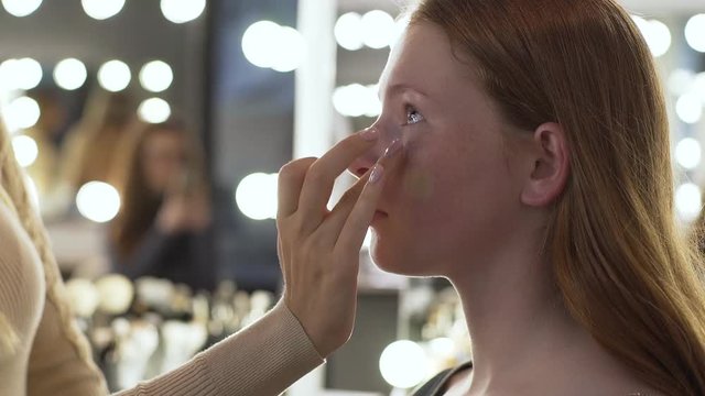 Makeup artist applying make-up on face of model