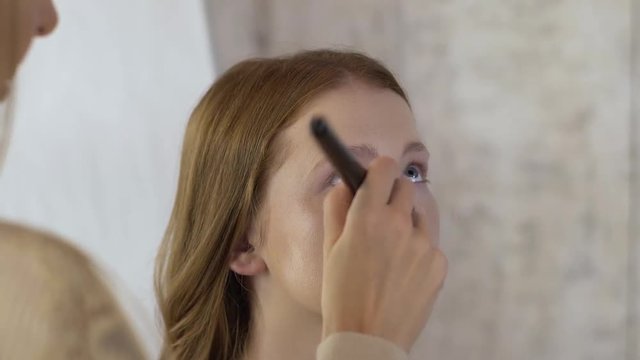 Makeup artist applying make-up on face of model