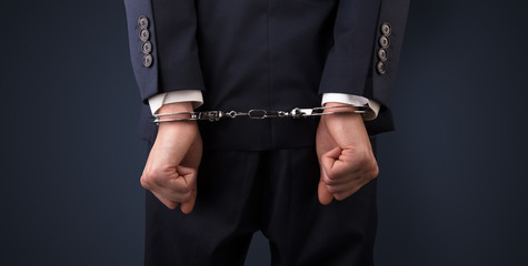 Close now arrested men hand with dark background and handcuffs
