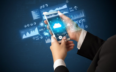 Female hand using smartphone with financial tracking concept illustrated by graphs and symbols