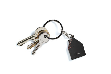 Schlüssel mit Schlüsselanhänger in Hausform, freigestellt auf weißem Hintergrund 