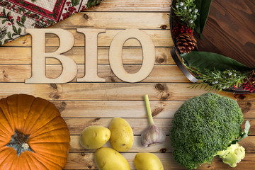 Wort BIO und verschiedene Gemüse auf Holzhintergrund 