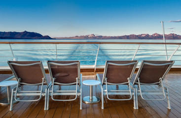 Row of empty plastic cruise ship deck lounge chairs early morning, Alaska, USA.