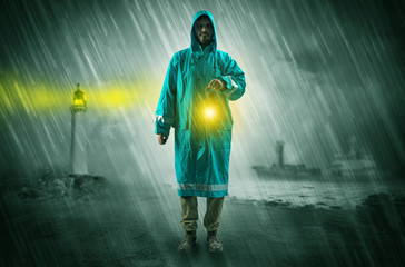 Fototapeta na wymiar Man at the coast coming in raincoat with glowing lantern concept 