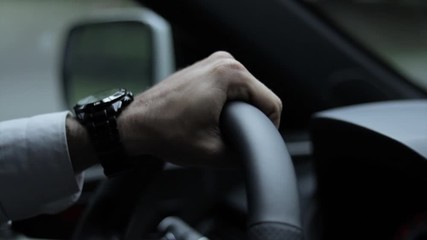 Hand gripping a steering wheel in slow motion