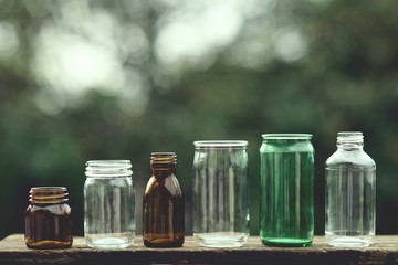Assorted series collection of empty transparent glass bottle container in white, green and brown...
