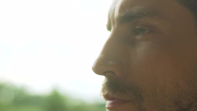 Male profile close-up on sunset background looking far, static shooting