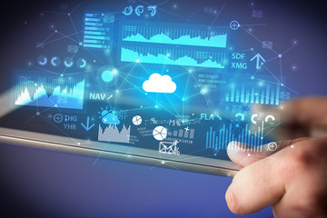 Businessman using tablet with flying application icons around
