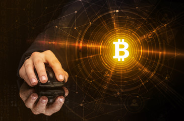 Hand using wireless mouse with cryptocurrency concept on dark background