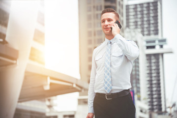 businessman standing talking phone in city 