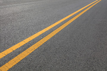 Yellow double solid line on the asphalt road - obrazy, fototapety, plakaty