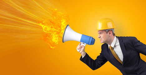 Fototapeta premium Young architect constructor yelling with megaphone with copyspace