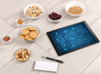 Healthy food composition with tablet. Body diagnosis on the screen