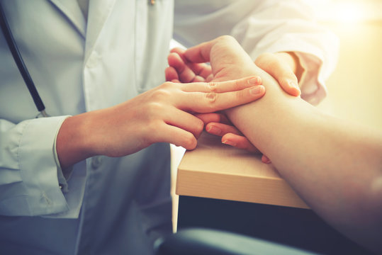 Doctor is checking pulse of patient