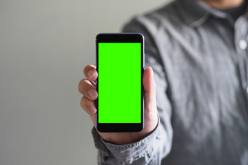 Business man showing Smartphone with green screen and Clipping path inside for video