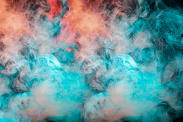 Fototapeta na wymiar Dynamic puffs of blue gray and orange colors on a black background smoothly flow coloring waves enveloping the sea foam. Decorative wallpaper with multi-colored smoke.