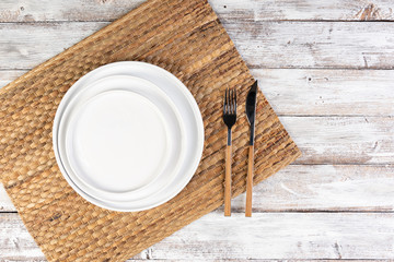 empty white dishes (plate, bowl) on a white wooden background (table), top view, copy space, mock-up
