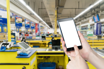 Female hand holding mobile smart phone on Supermarket blur background, business concept