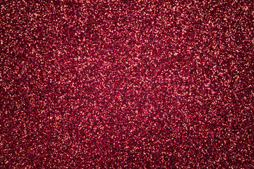 Dark red sparkling background from small sequins, closeup. Brilliant backdrop.
