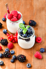  yogurt with raspberries, blackberries, currants, mint leaves. the concept of diet food and vitamins, Breakfast at the hotel. selective focus
