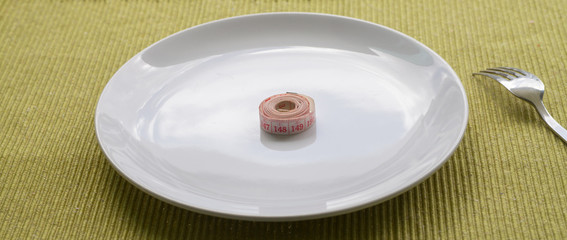 measuring tape folded on white plate