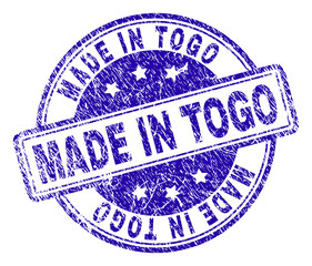 MADE IN TOGO stamp seal imprint with distress texture. Designed with rounded rectangles and circles. Blue vector rubber print of MADE IN TOGO caption with corroded texture.