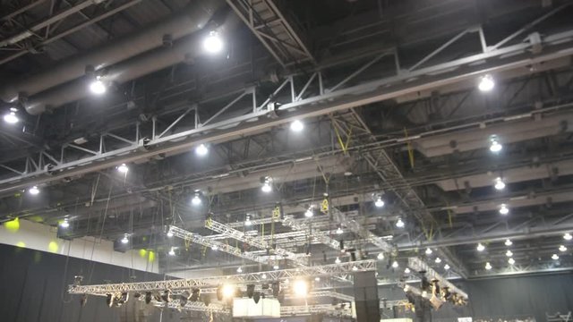 unfocused concert hall. audience people sitting conference concert hall seats dark night light rays inside exhibition fair blurred mooving camera meeting business.