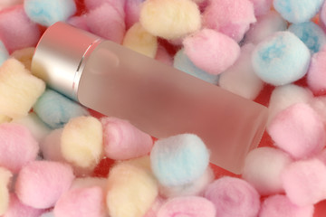 Facial cleansing toner on a pink background and cotton wool