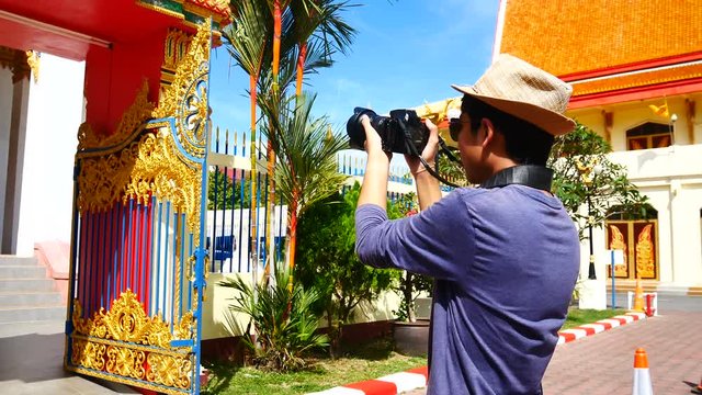 Travel Video A tourists blogger from Southeast Asia is walking in the old town to take a photo of temple in Phuket Old Town to write a tourist review. During vacation in travel concept.