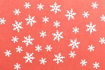 Trendy living coral color of year 2019 flat lay of white snowflakes