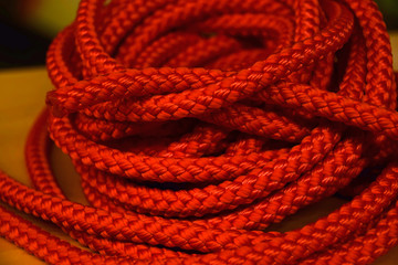 coiled orange industrial rope made of nylon or synthetic, roll of orange rope for sale