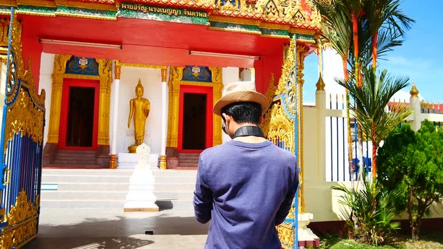 Travel Video A tourists blogger from Southeast Asia is walking in the old town to take a photo of temple in Phuket Old Town to write a tourist review. During vacation in travel concept.