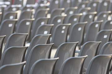 Rows of empty dark chairs. Abstract. Back view