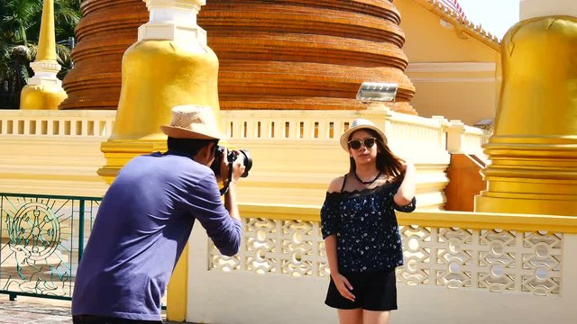 A tourists blogger from Southeast Asia is taking a photo to a co-worker trip in Phuket Old Town to write a tourist review. During vacation in travel.