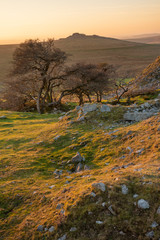 Stunning landscape sunset image over abandoned Foggintor Quarry in Dartmoor with raking soft sunlight over ruins and derelict buildings