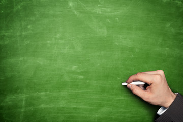 Businessman hand holding chalk and pointing on blackboard
