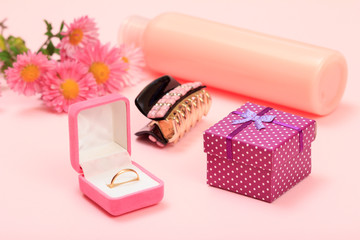 Obraz na płótnie Canvas Gift boxes and cosmetics on a pink background with flowers.