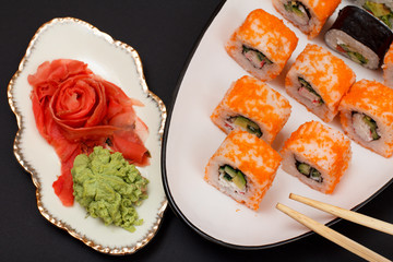 Uramaki California. Sushi rolls and pickled ginger and wasabi.