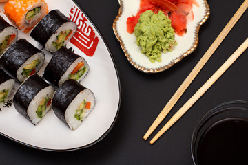 Sushi rolls in nori seaweed sheets and pickled ginger and wasabi.