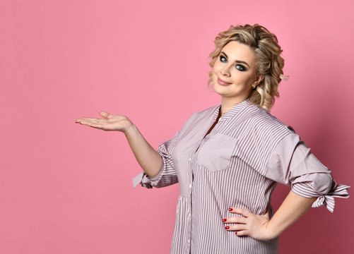 Woman in shirt thinking show pointing open hand with free empty text space on modern