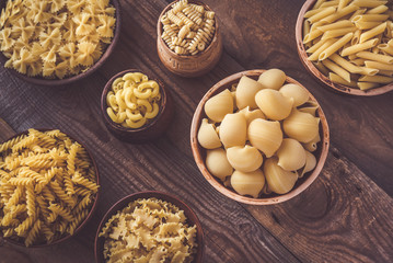 Various types of pasta on rustic background