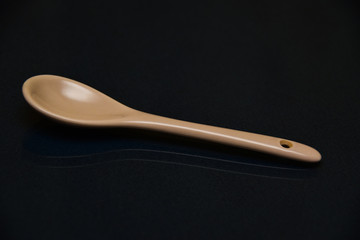 A porcelain spoon on a black background.