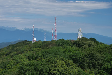 cell towers placed on the top of the hill. Snowy mountains are visible in the background.