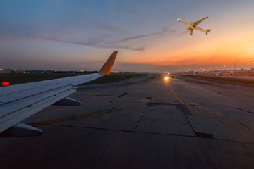 Fototapeta premium Airplane is taxiing to the runway for take off in beautiful sunset.