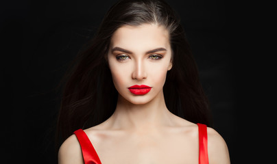 Sensual woman brunette with dark straight hair and red lips makeup on black background